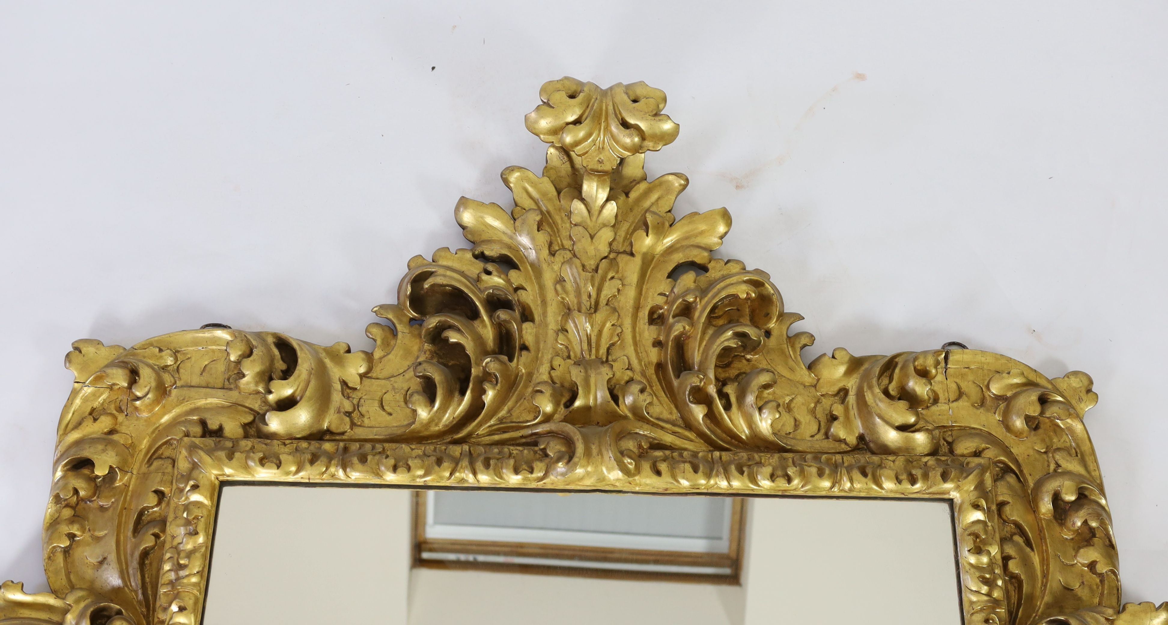 A mid 19th century Florentine ornately carved giltwood wall mirror, W.166cm H.158cm
